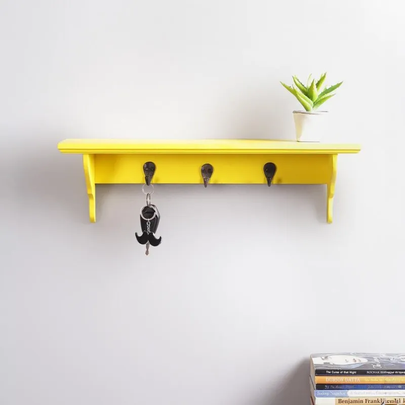 Front view of yellow wooden wall shelf with three hooks