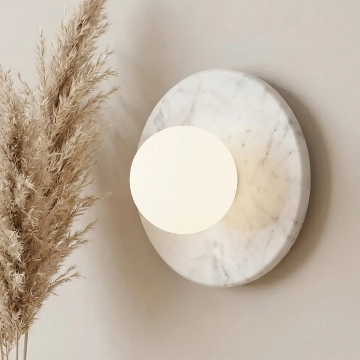 Close view of the circular marble-look wall lamp with frosted globe diffuser