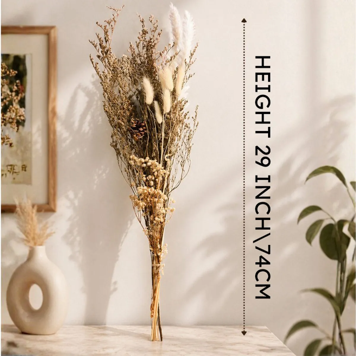 Tall dried flower bouquet standing against a wall in a softly lit setting