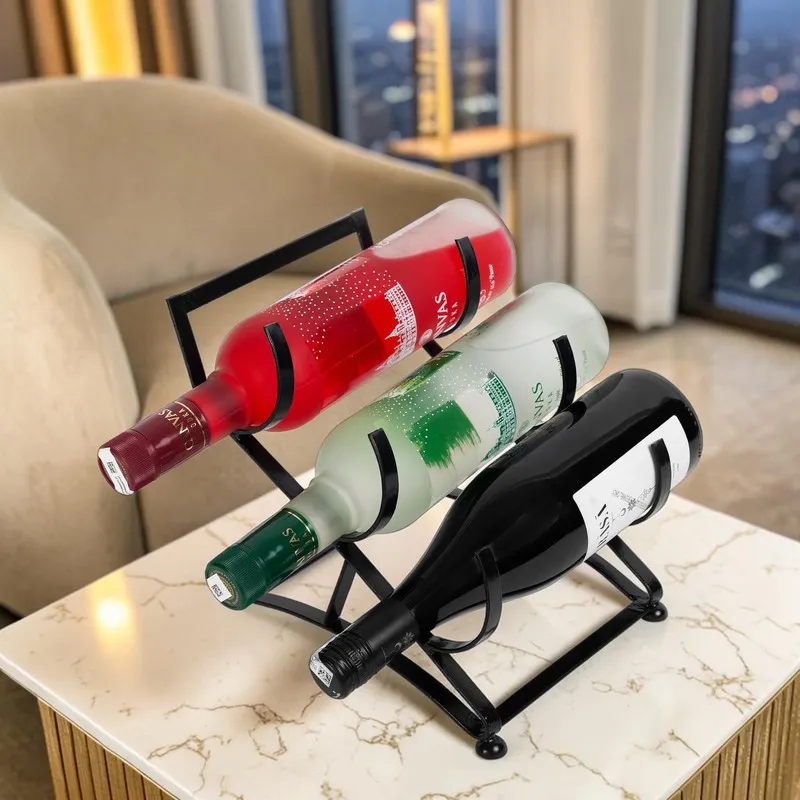 Black bottle holder with three wine bottles beside a window at night.