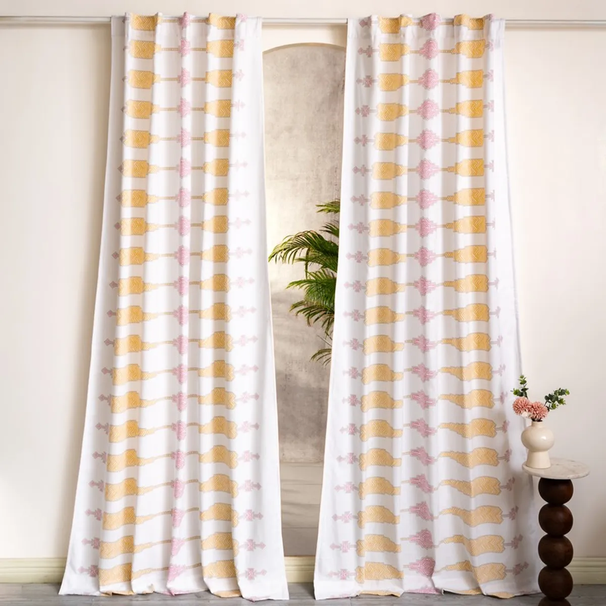 Pair of white patterned curtains hanging on a large window