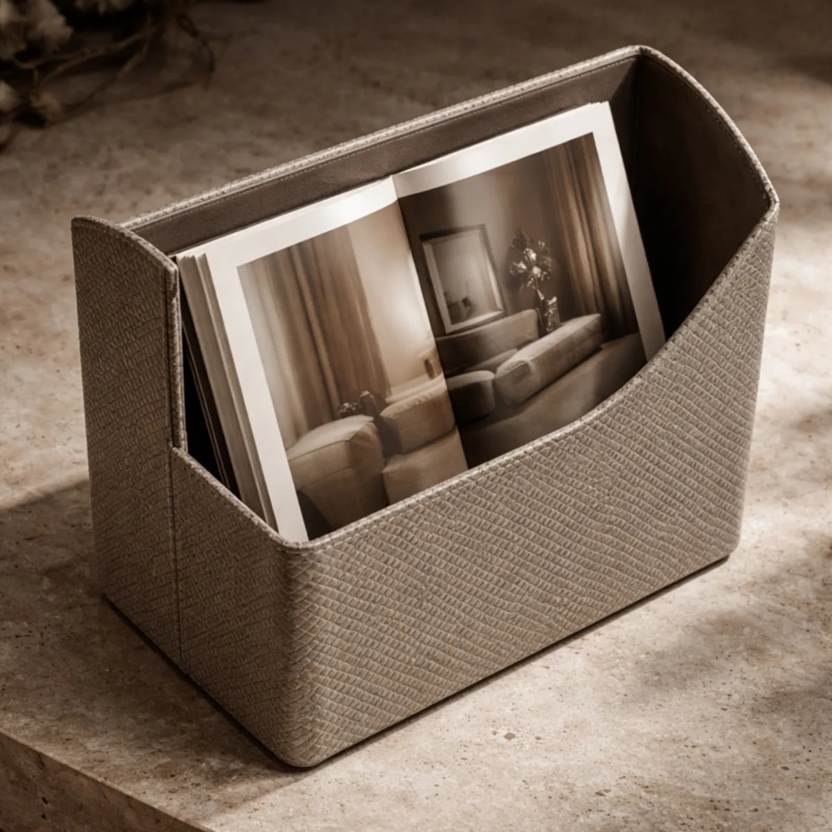 Grey textured desk organiser holding an open interior design book