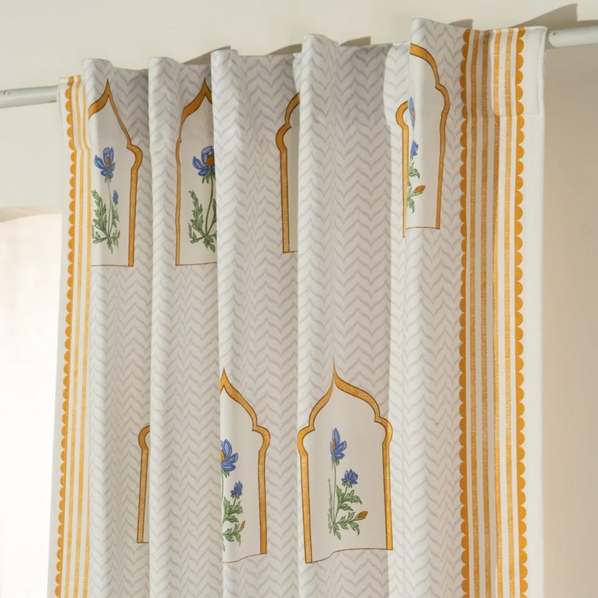 Close-up of curtain pleats with floral arch pattern and back tabs