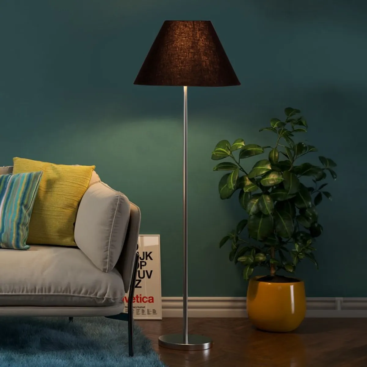 Lit black floor lamp beside a sofa and plant against a teal wall