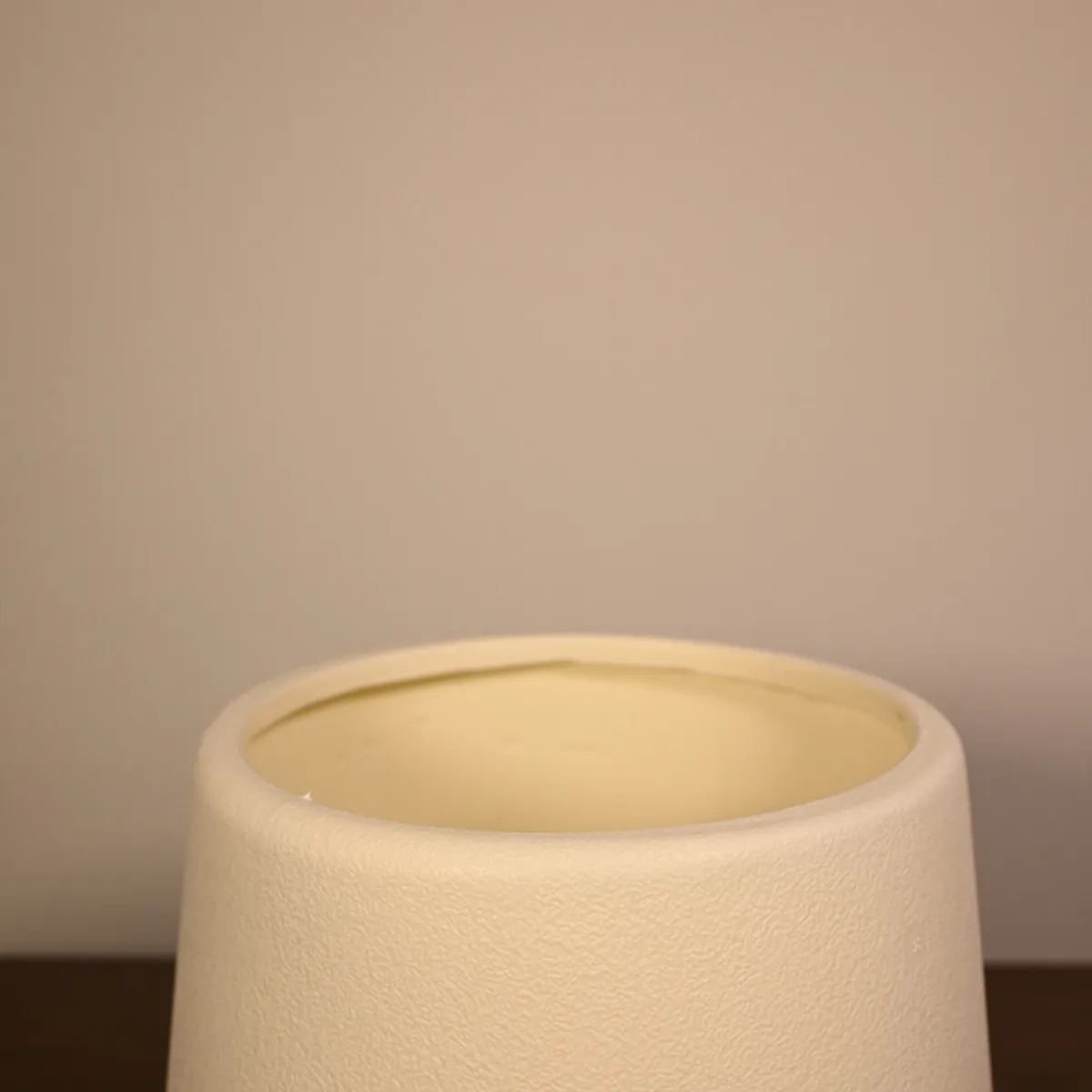Close-up of the open rim and textured white surface of a planter