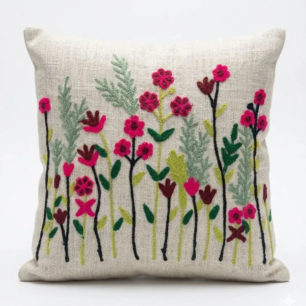 Close-up of a white cushion cover with colourful embroidered flowers and foliage.