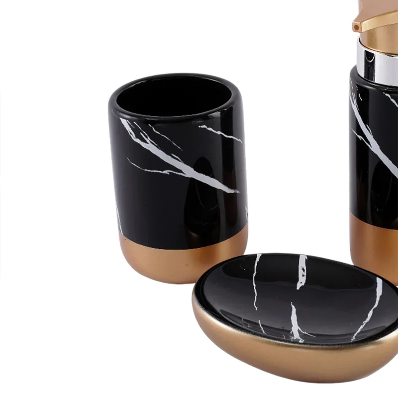 Close view of black and gold marbled soap dish and bathroom tumbler