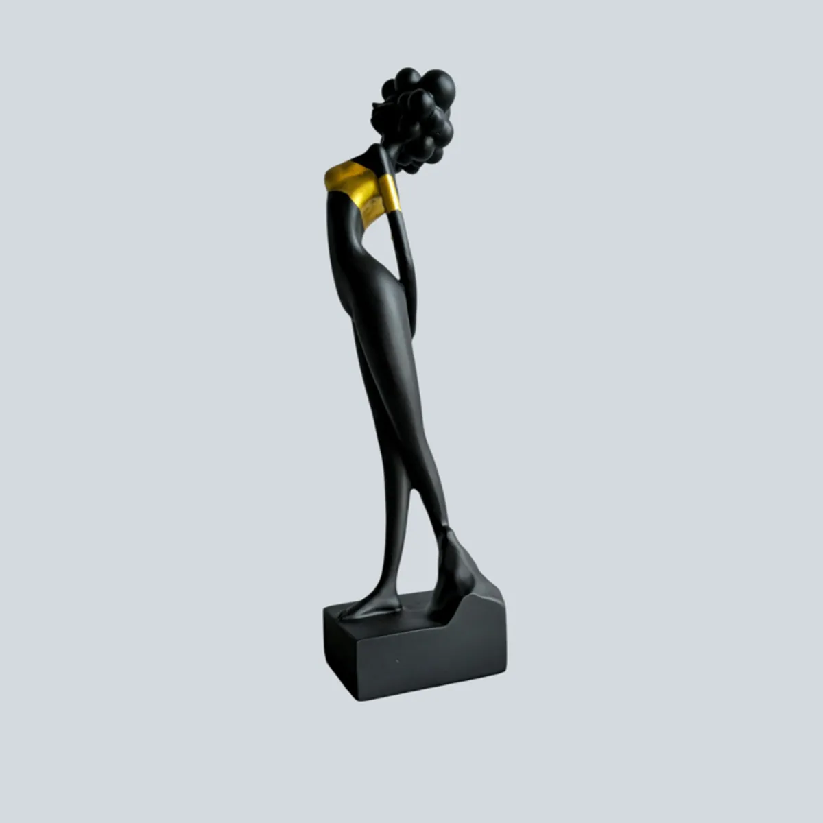 Side view of a black and gold sculptural lady figurine