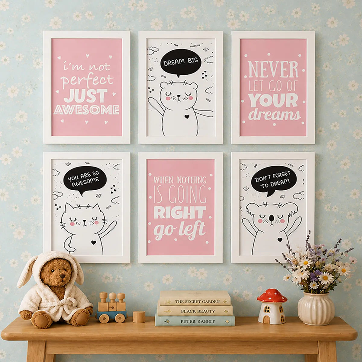 Six white-framed pink and black wall art prints displayed above a wooden console with soft decor.
