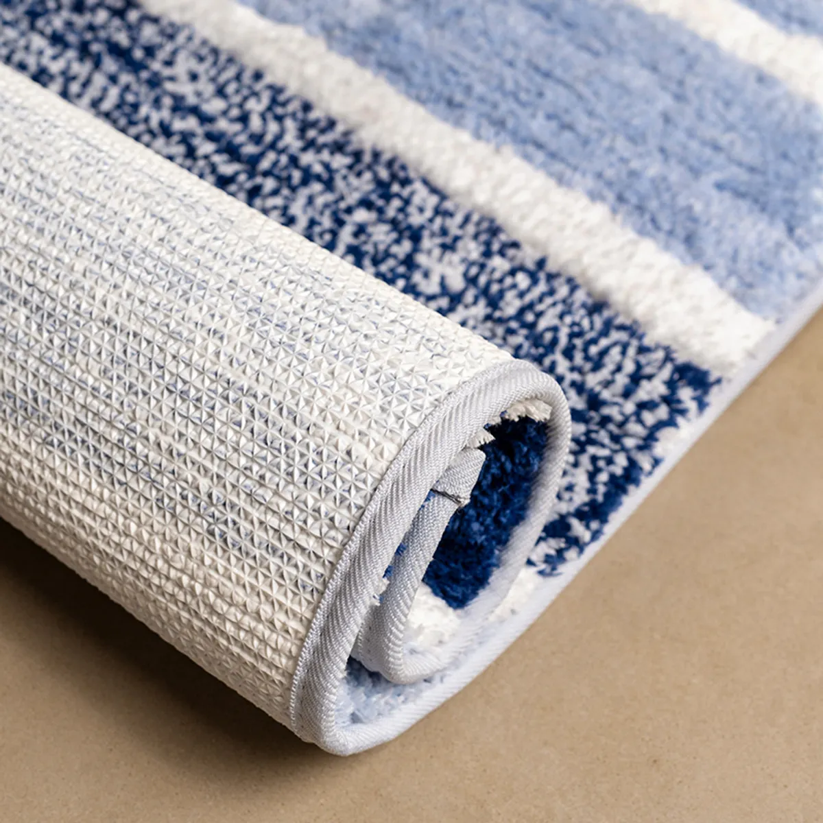 Rolled blue striped runner showing its textured white anti-skid backing
