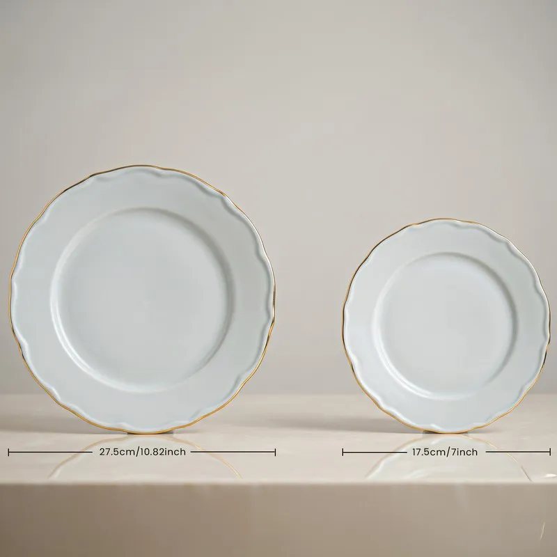 Two white round plates with gold rims shown side by side
