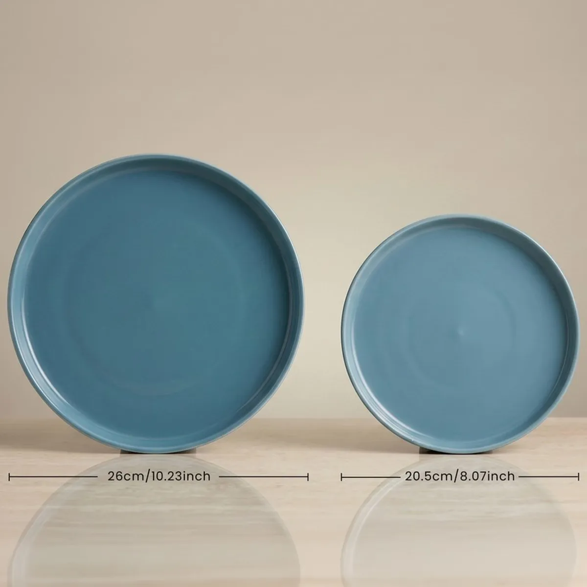 Two blue round plates from the dinner set shown side by side
