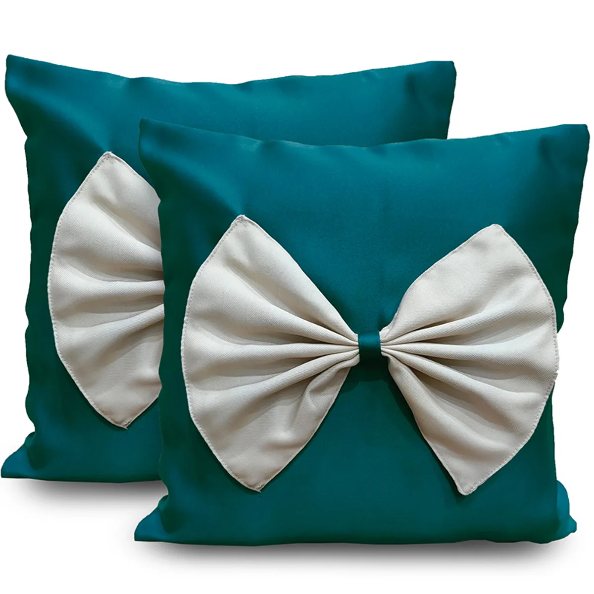 Pair of teal-green square cushion covers with large white bow fronts on white background