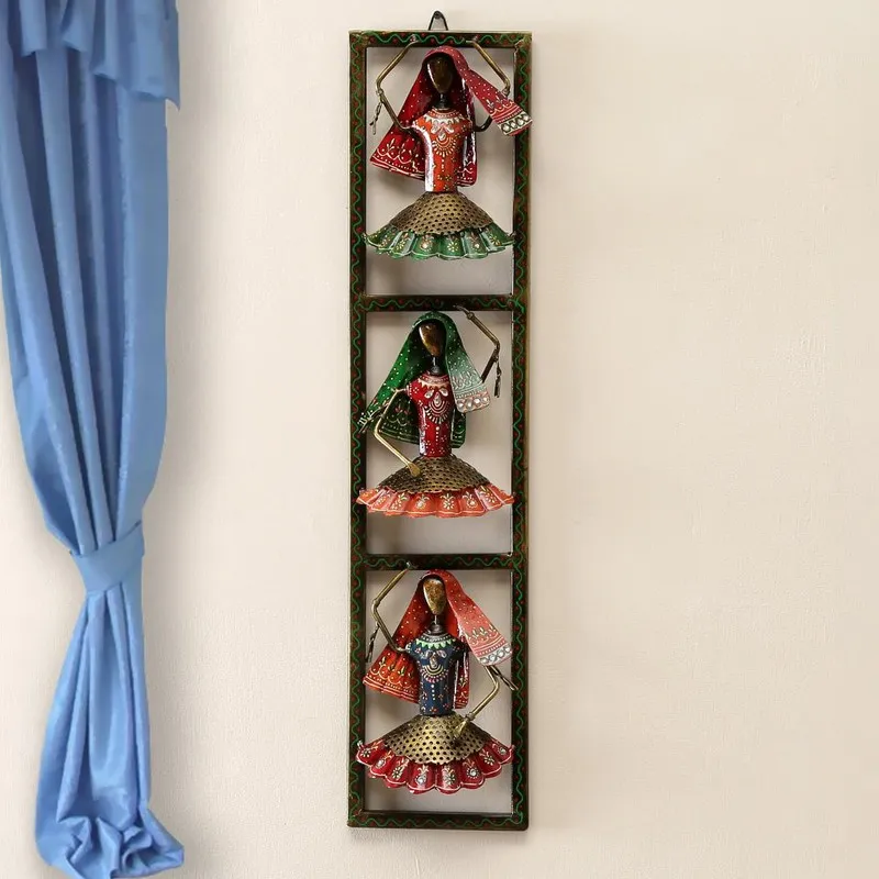 Vertical metal wall decor with three colourful figurines mounted on a wall