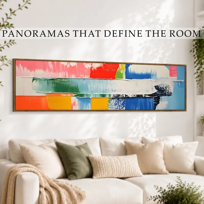 Framed panoramic abstract canvas displayed above a white sofa in a bright living room.