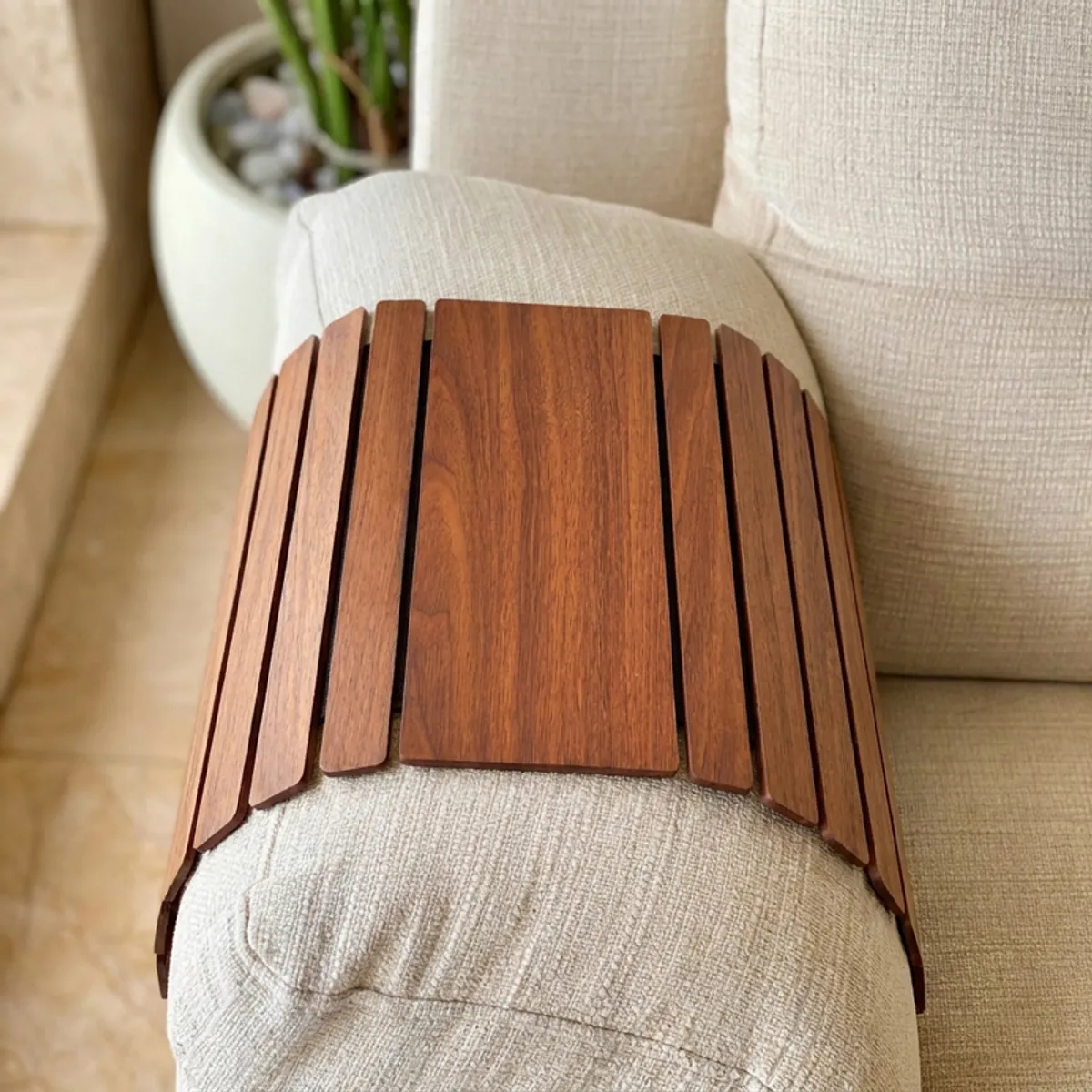 Top view of a brown slatted sofa armrest tray on a recliner