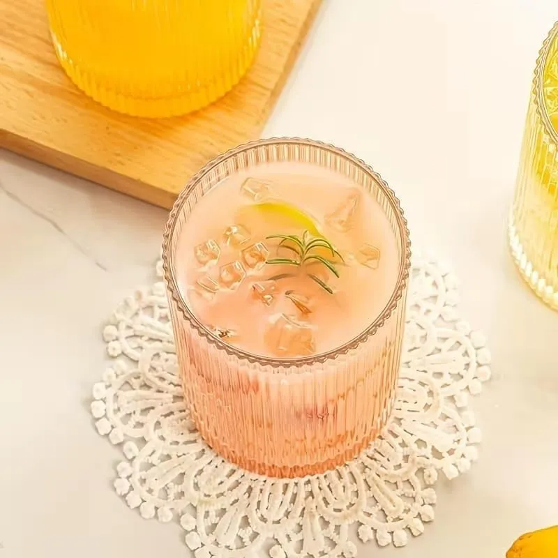 Top view of a clear glass with a pink drink and ice cubes