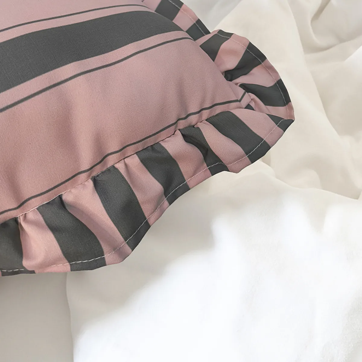 Close-up of pink and grey striped fabric and ruffled cushion cover edge