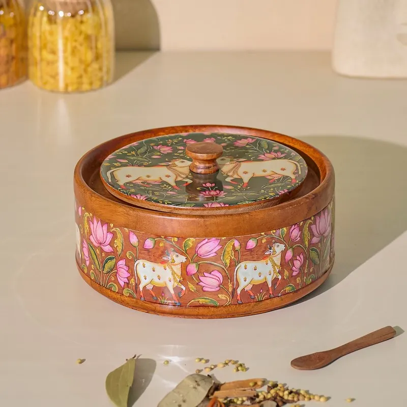 Closed round masala box showing glossy brown wood and floral figurative artwork