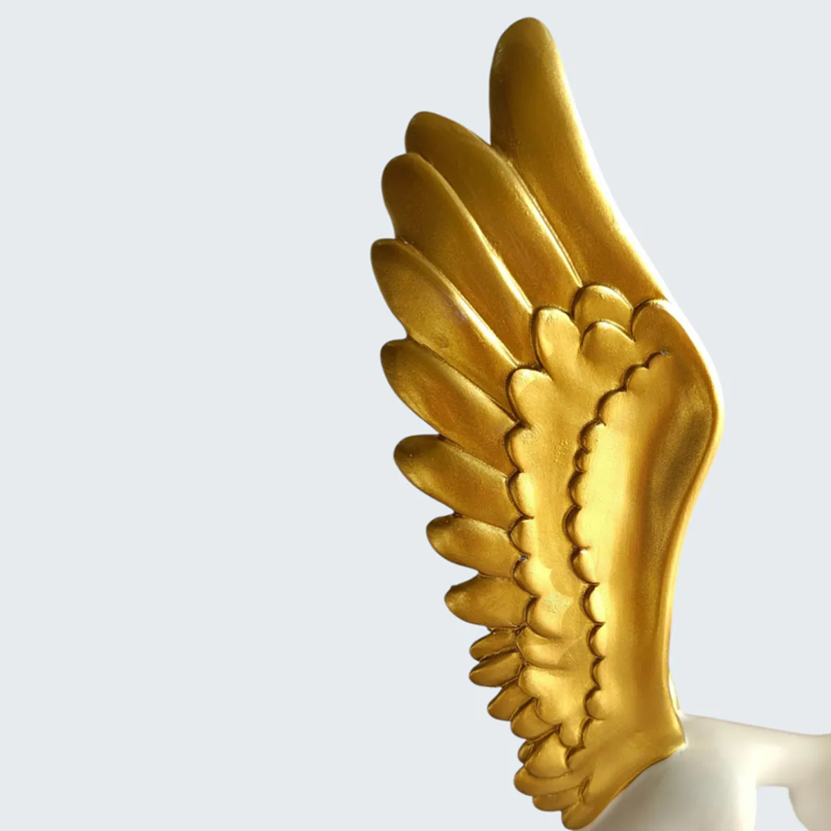 Close-up of the gold wing detail on the abstract figurine