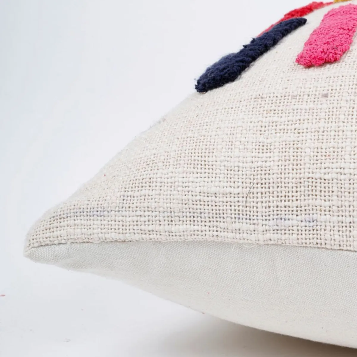 Close-up of the textured cream cushion cover fabric and finished edge