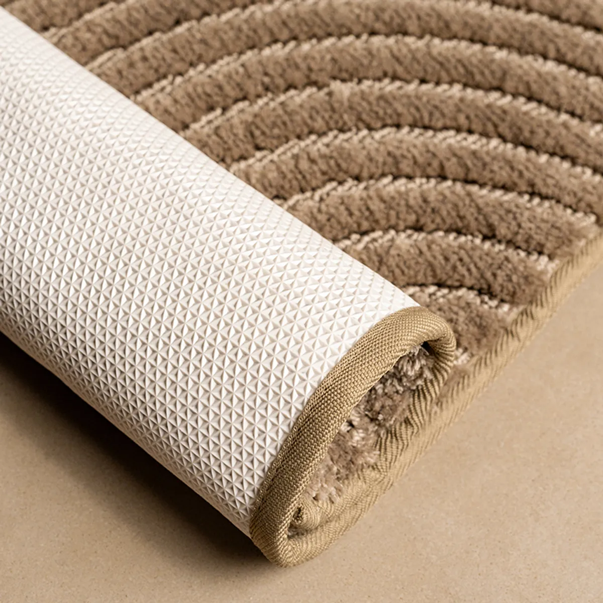 Rolled beige runner rug showing its textured surface and anti-slip backing.