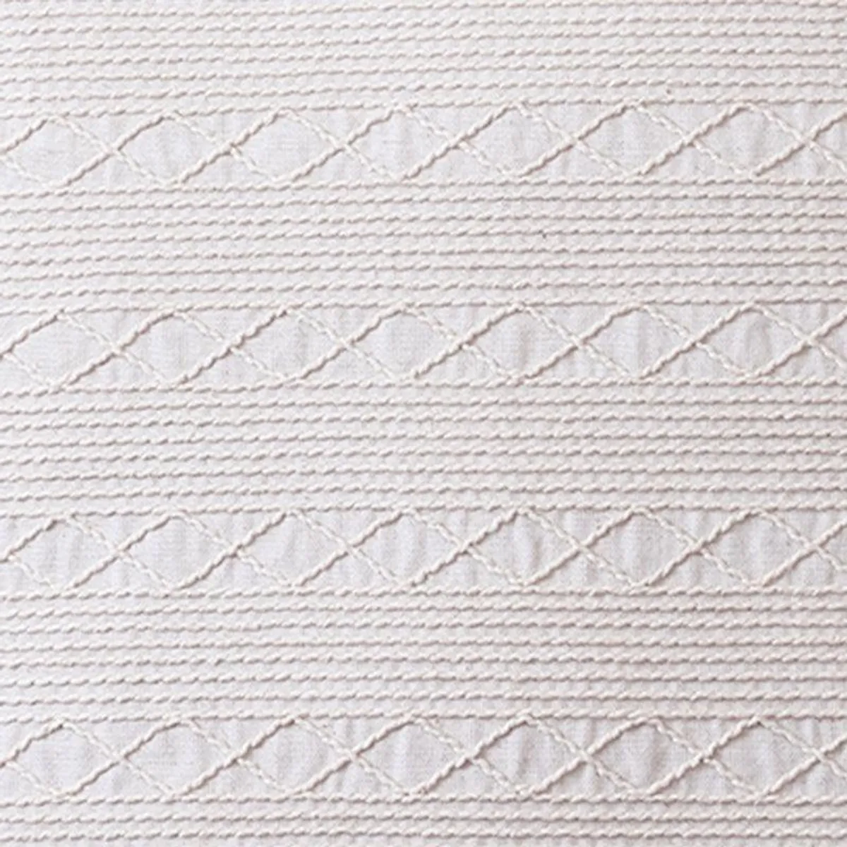 Close-up of white cushion cover showing raised horizontal embroidered geometric bands