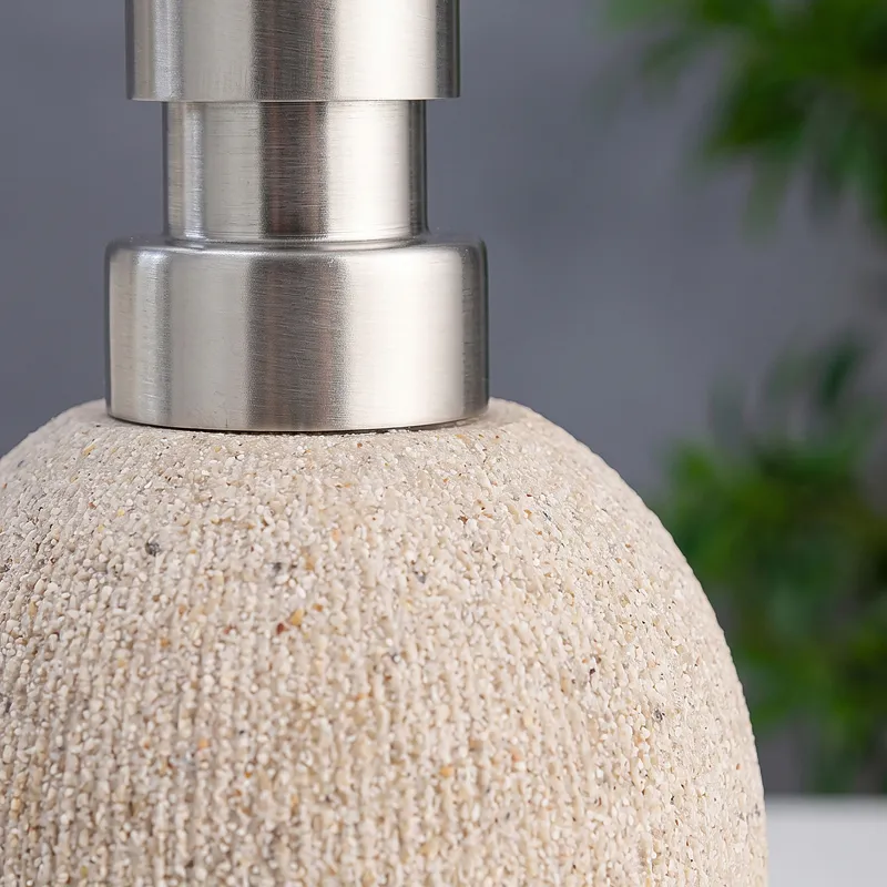 Close-up of the textured beige dispenser body and silver pump