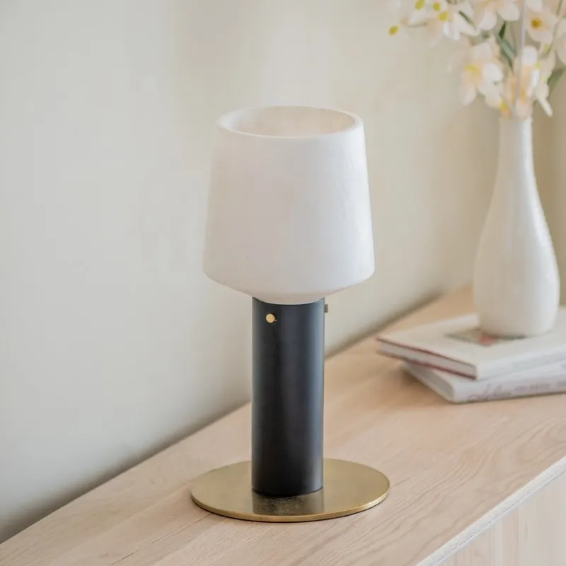 Black and off-white cylindrical table lamp on a wooden console