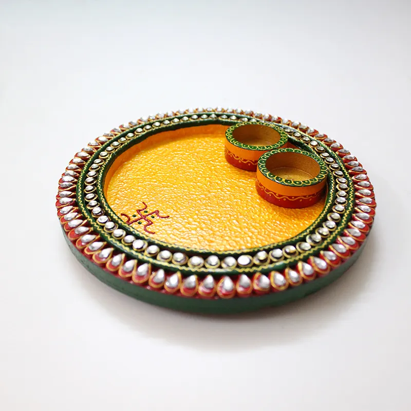 Front angled view of a handcrafted yellow pooja thali with two bowls
