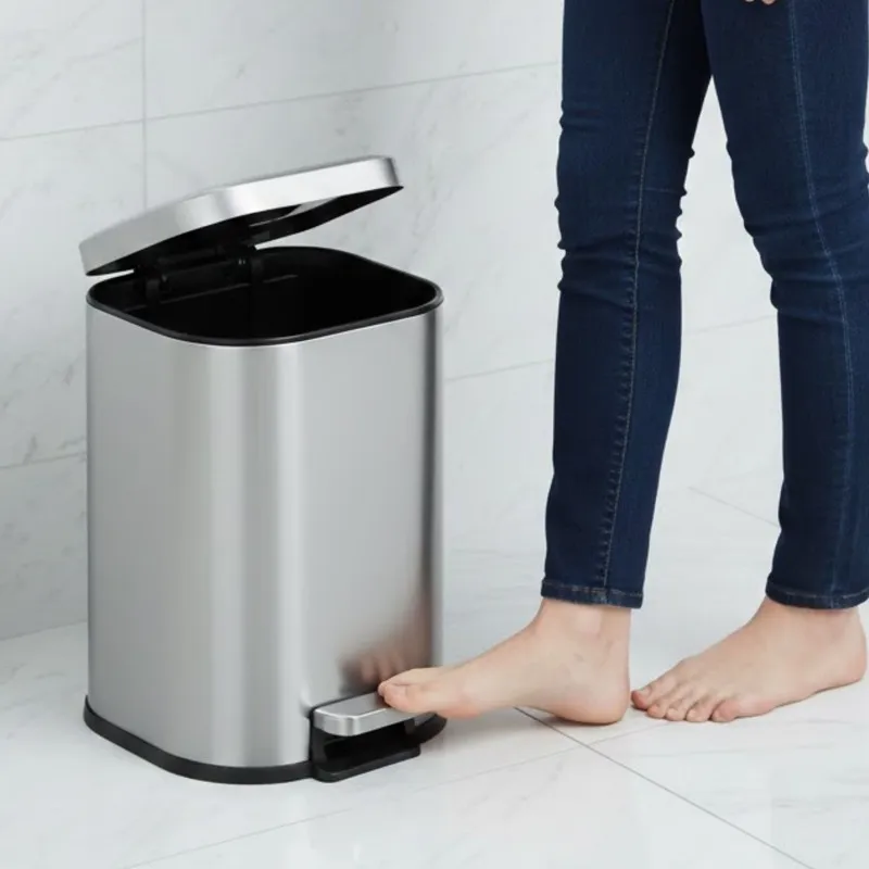 Silver pedal dustbin with open lid shown beside a person