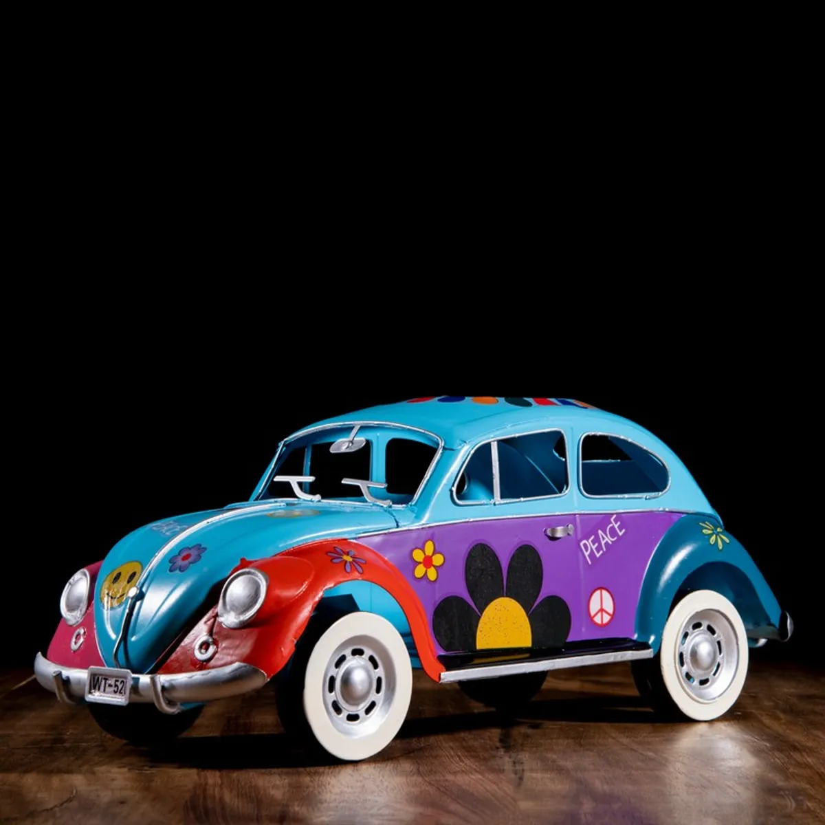 Side view of a multicolour vintage car showpiece with blue roof and floral motifs
