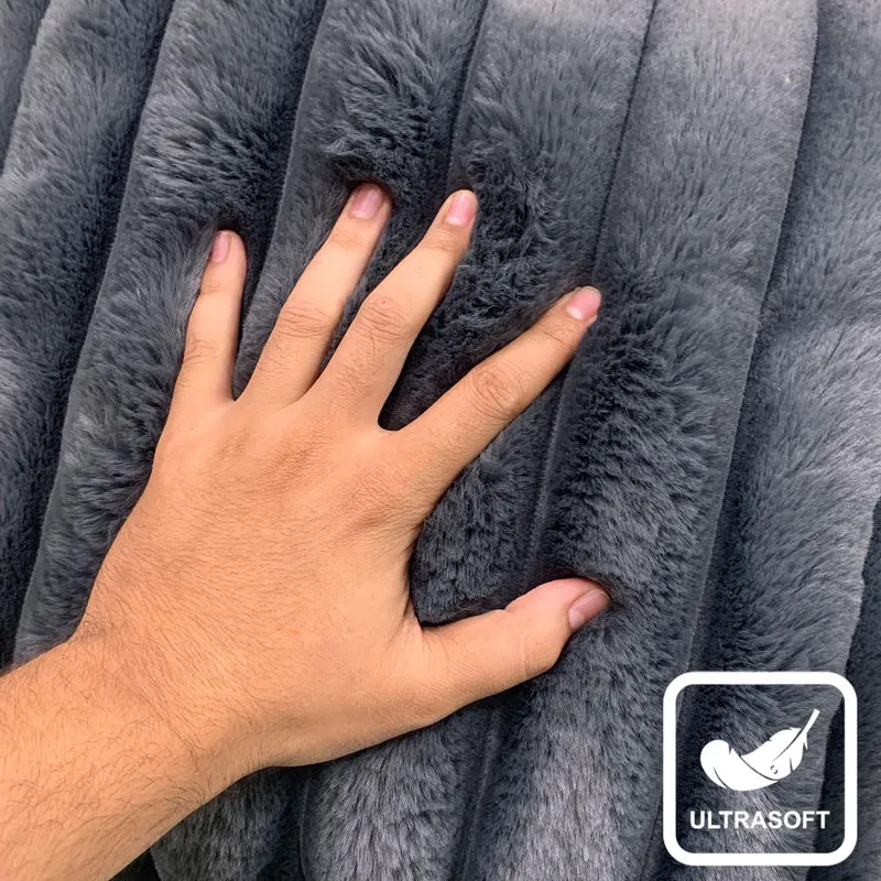 Hand resting on the plush grey faux-fur surface of a cushion cover