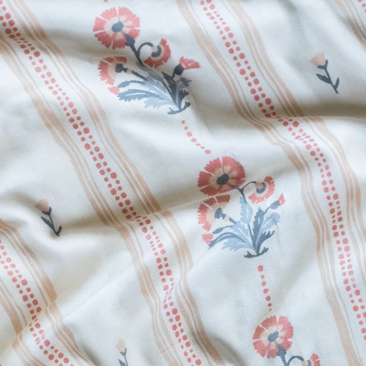 Close-up of cotton curtain fabric with pink, blue and beige floral details