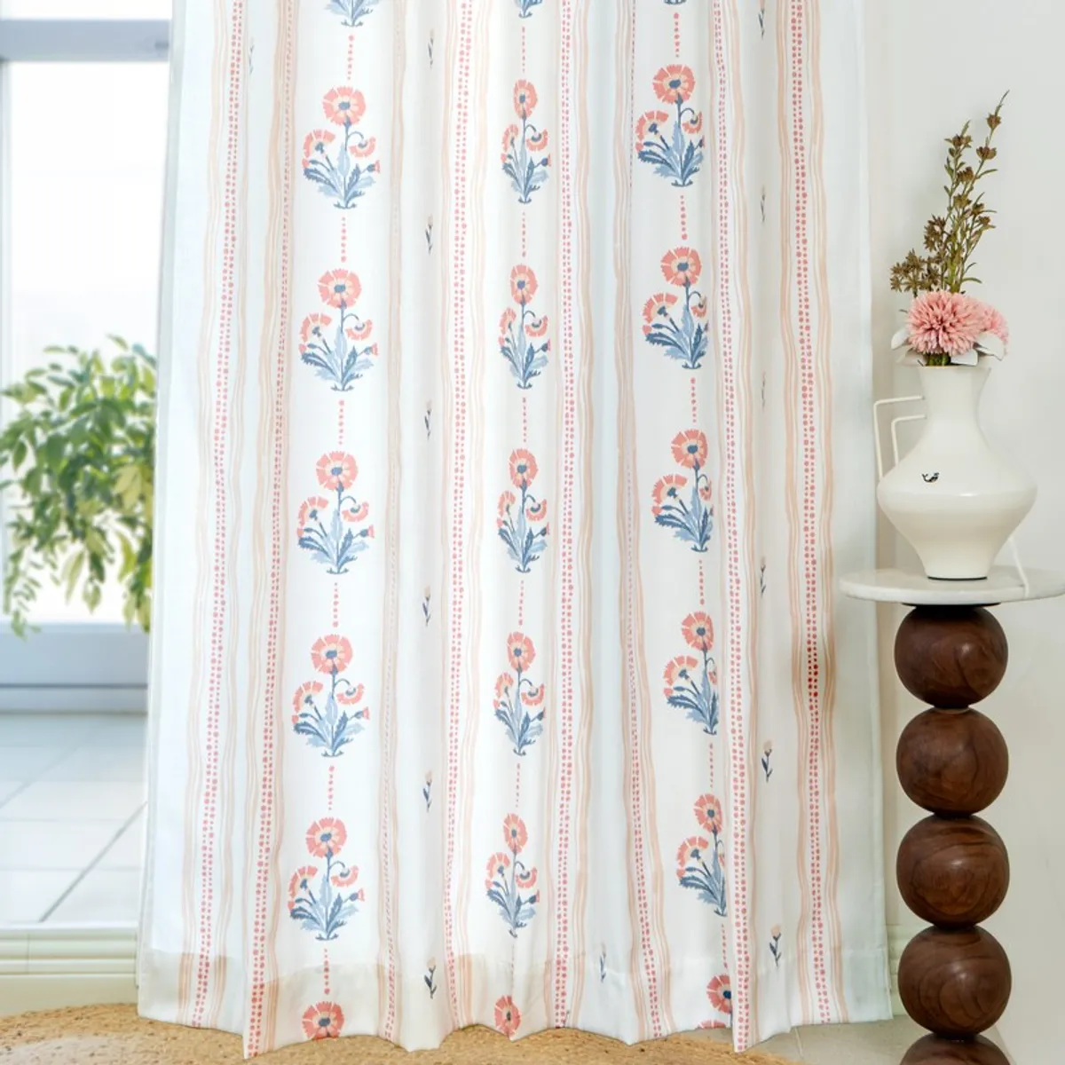 Full-length off-white curtain with vertical pink and blue floral stripes