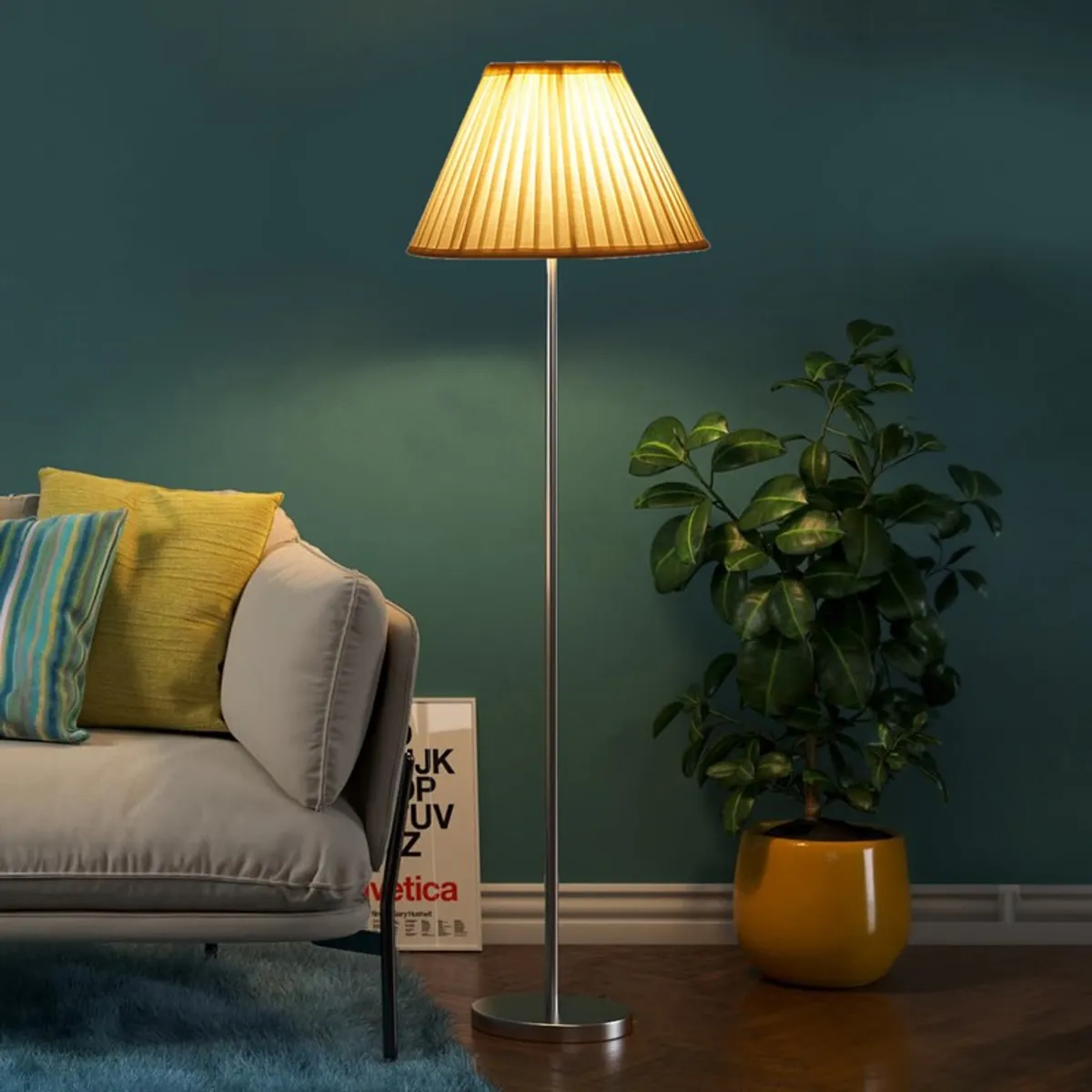 Lit pleated floor lamp beside a sofa and leafy plant against a dark teal wall