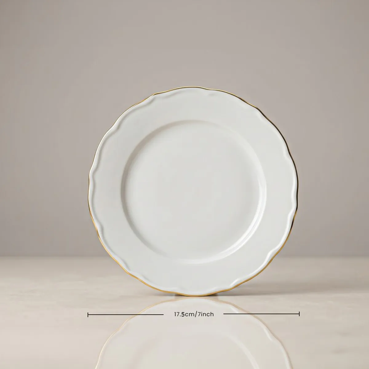 Front view of a white porcelain plate with gold rim
