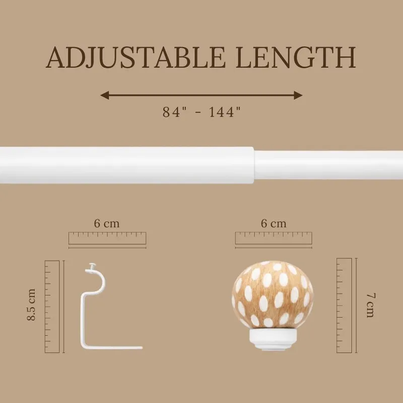 Extendable white curtain rod with round polka dot finial and bracket detail