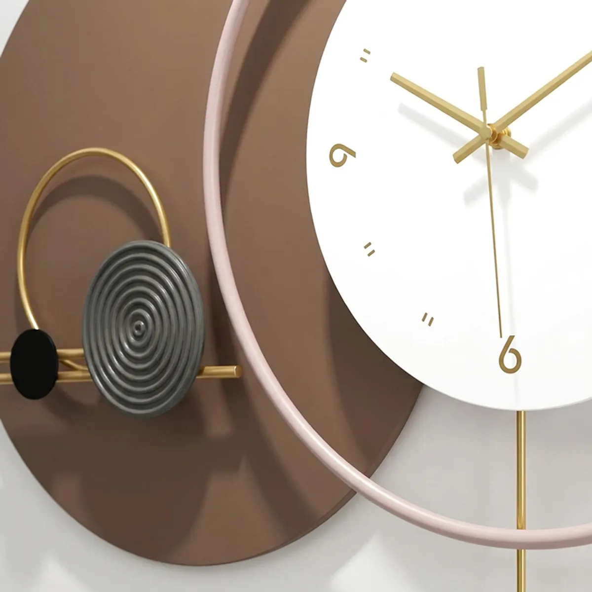Close-up of the wall clock showing white dial, gold hands and layered circular details