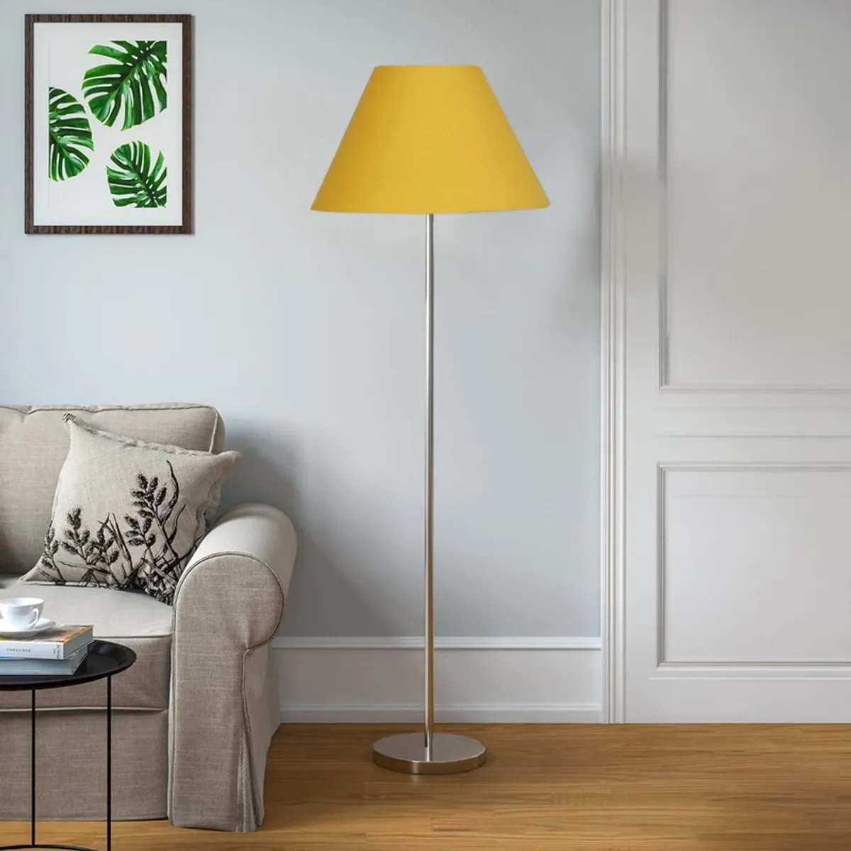 Yellow floor lamp with conical shade beside a sofa in daylight