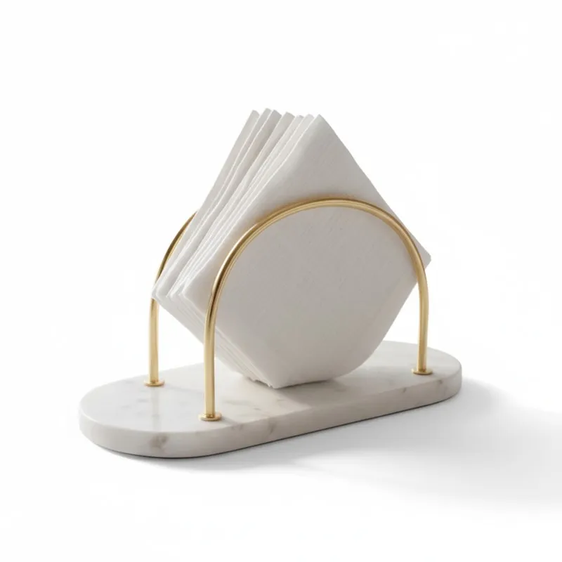 White marble tissue holder with gold arches holding folded napkins