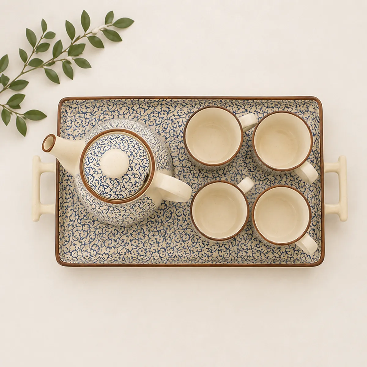 Top view showing the patterned teapot, four cups and serving tray