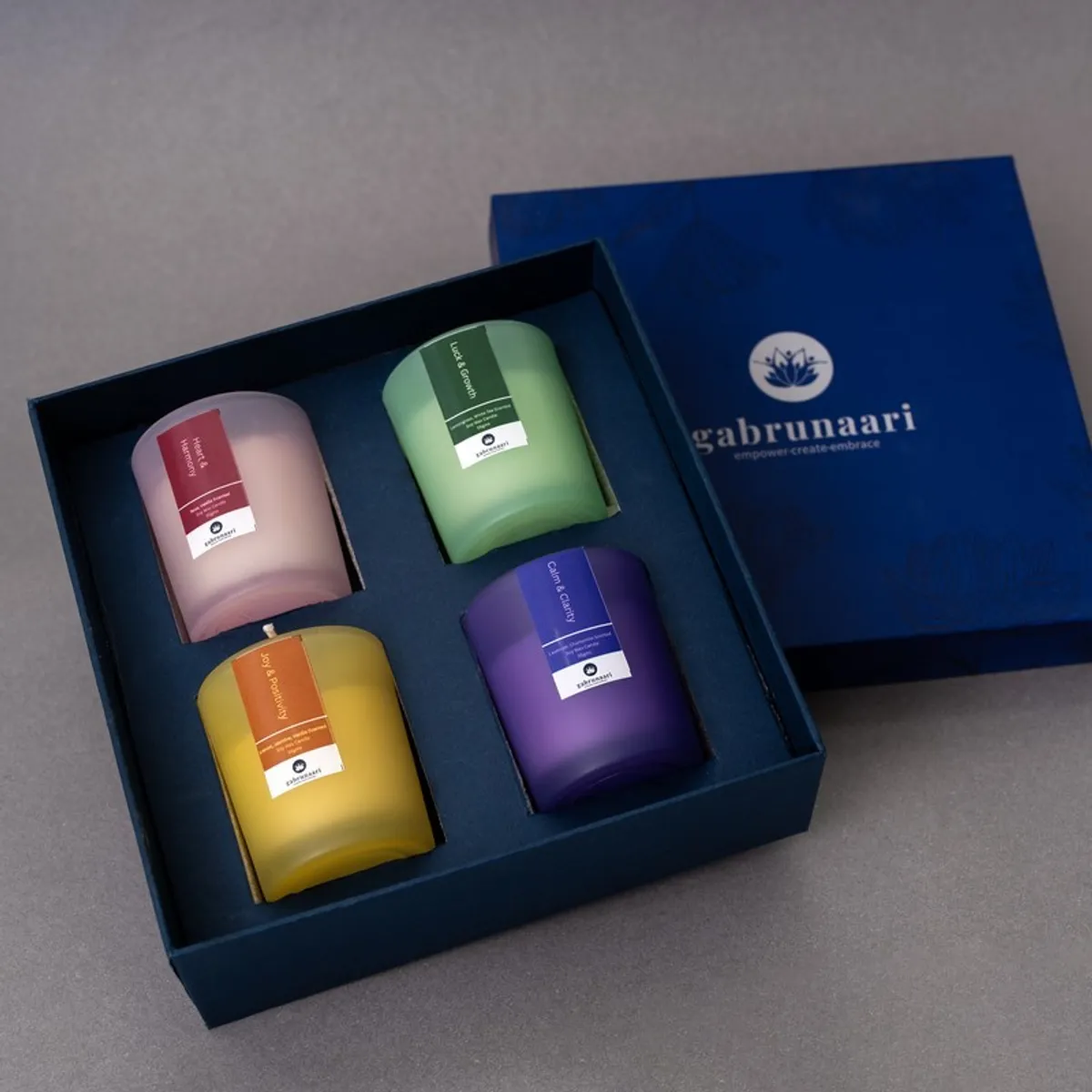 Four coloured candles arranged in an open blue gift box
