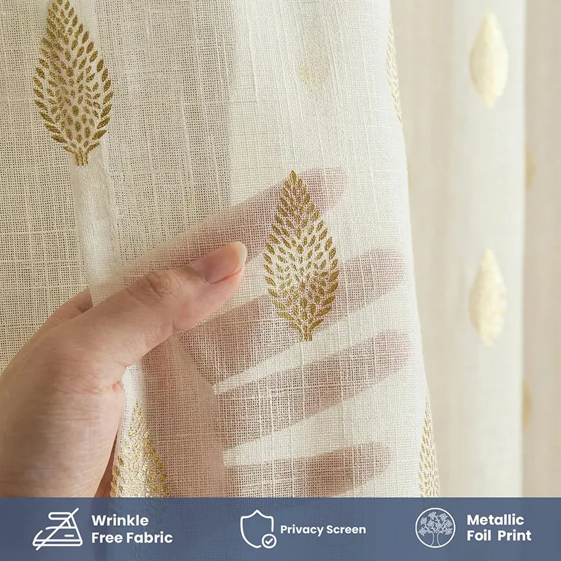 Close-up of white curtain fabric with gold leaf print and textured weave