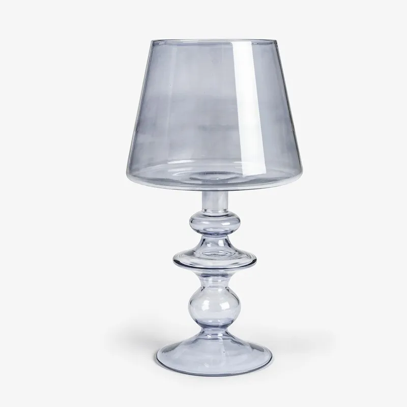Front view of a grey glass candle holder with an irregular silhouette