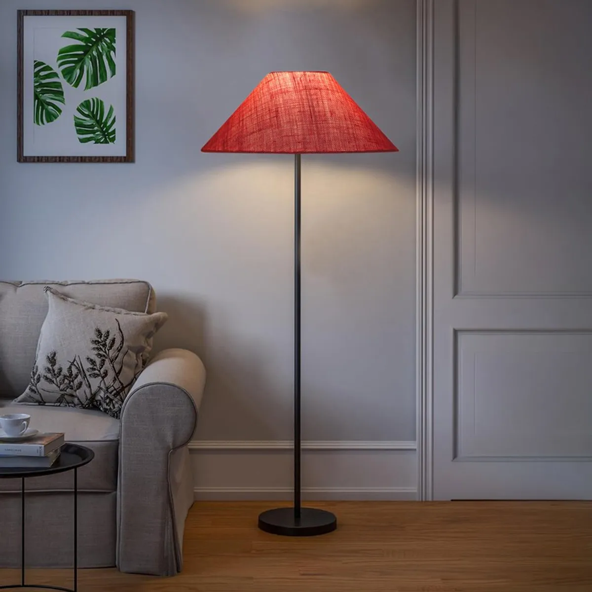 Pink floor lamp glowing beside a sofa in a muted room setting