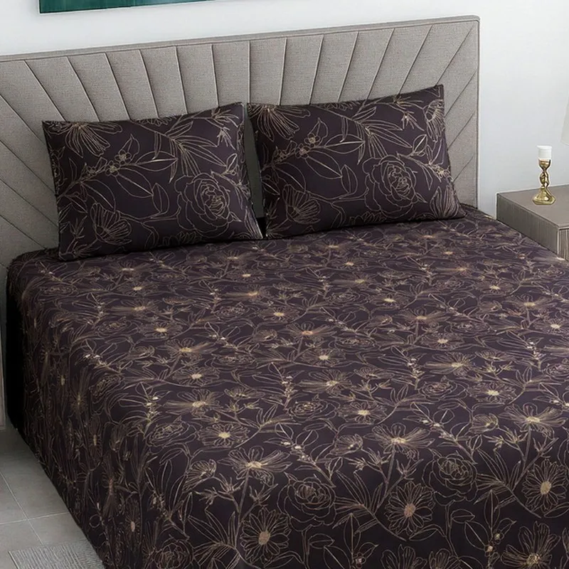 Close view of dark purple floral bedsheet with matching pillow covers on a bed