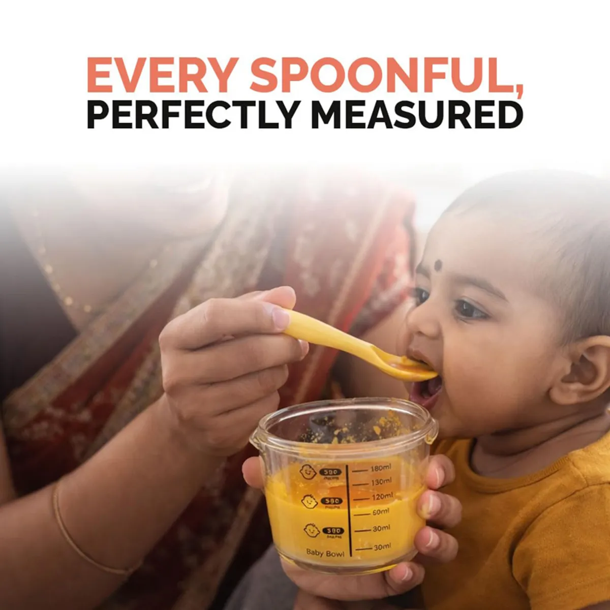Person feeding a baby using a marked glass bowl