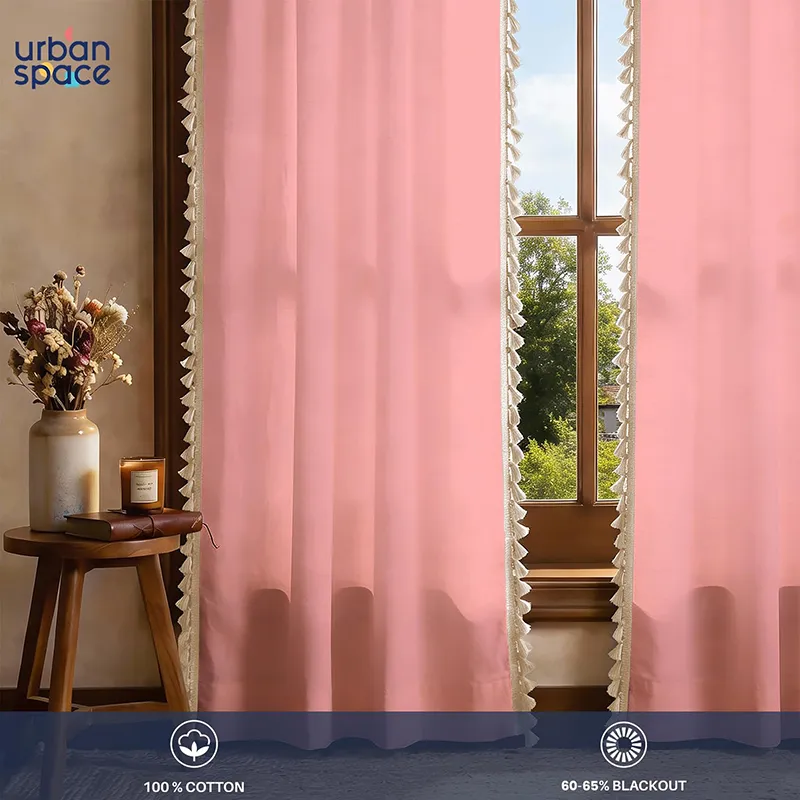 Two pink tasselled curtains styled by a window in a warm-toned room