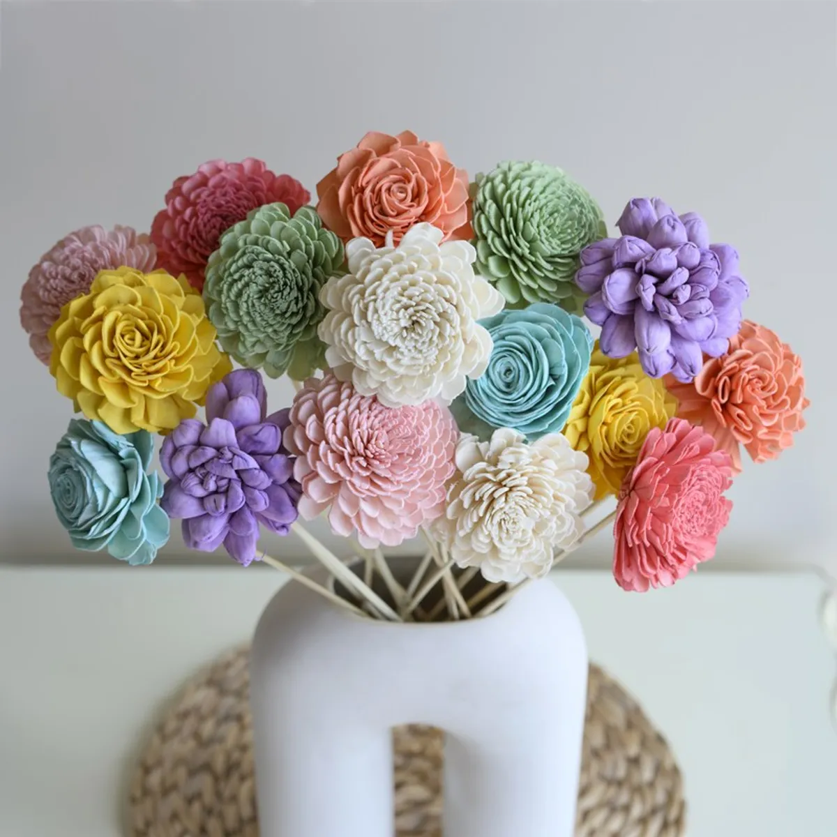 Close-up of pastel layered flower heads arranged in a white vase